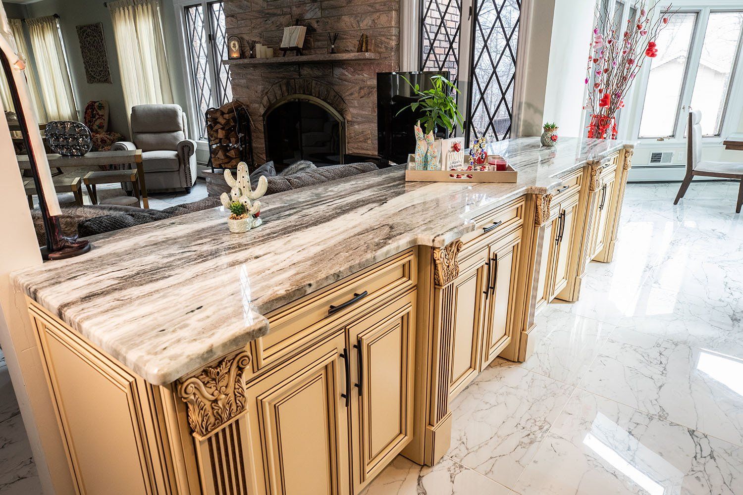 A kitchen with a large island and marble counter tops.