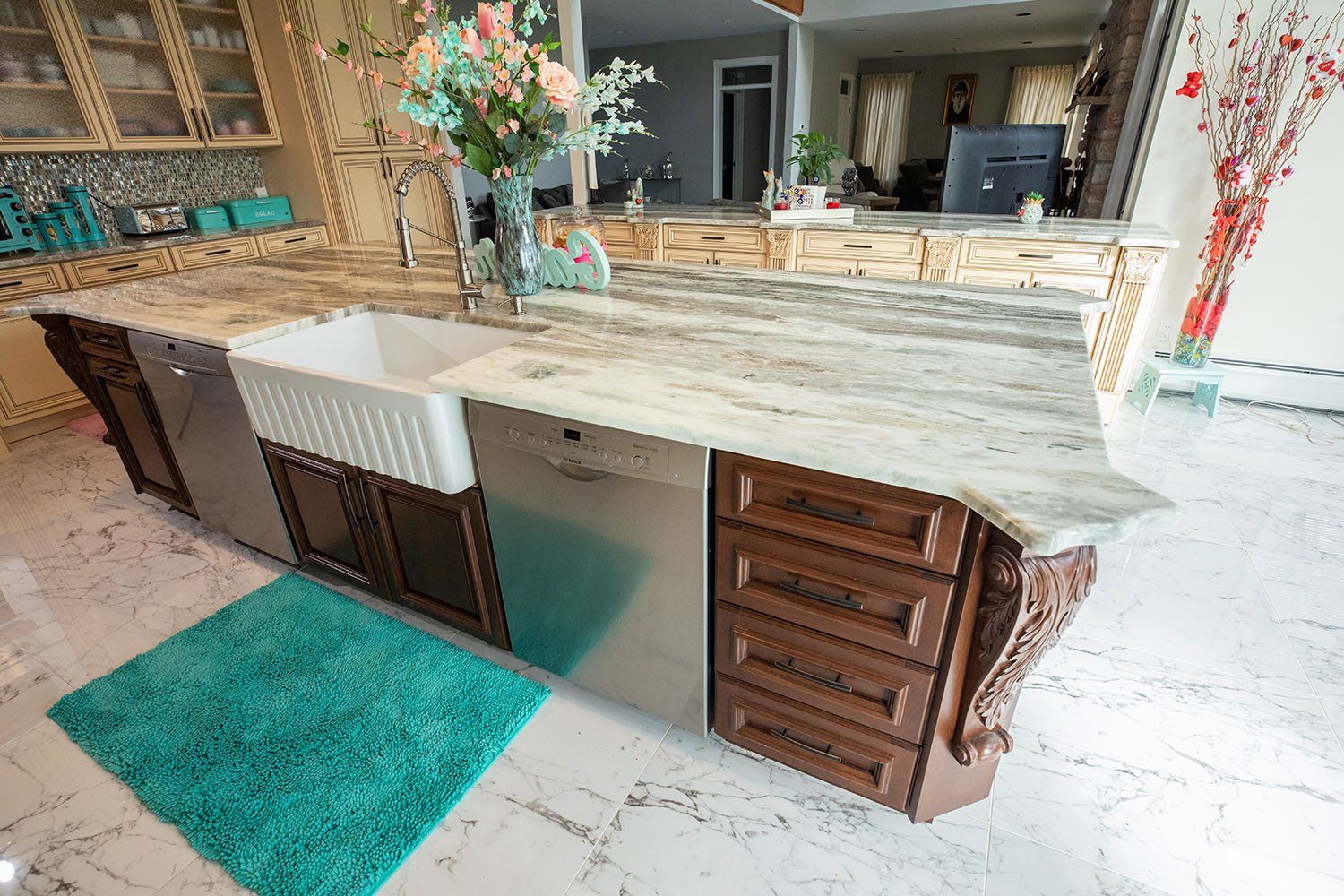 A kitchen with a large island , a sink , and a dishwasher.