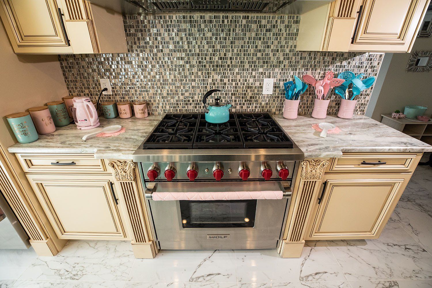 A kitchen with a stove top oven and a kettle on it.