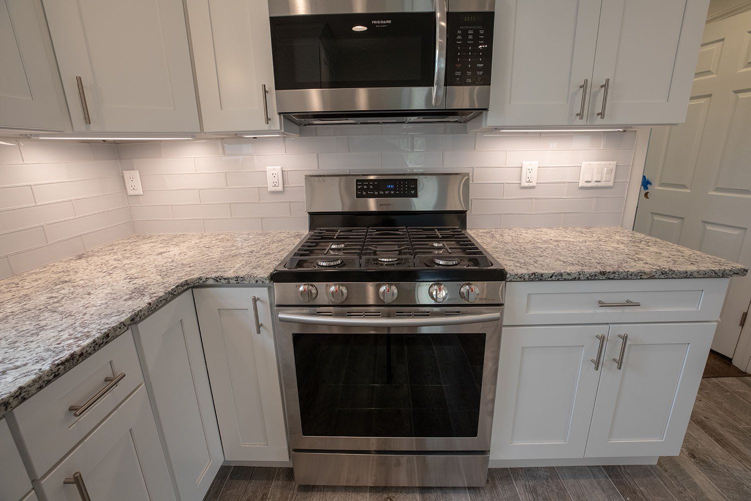 A kitchen with stainless steel appliances and granite counter tops.