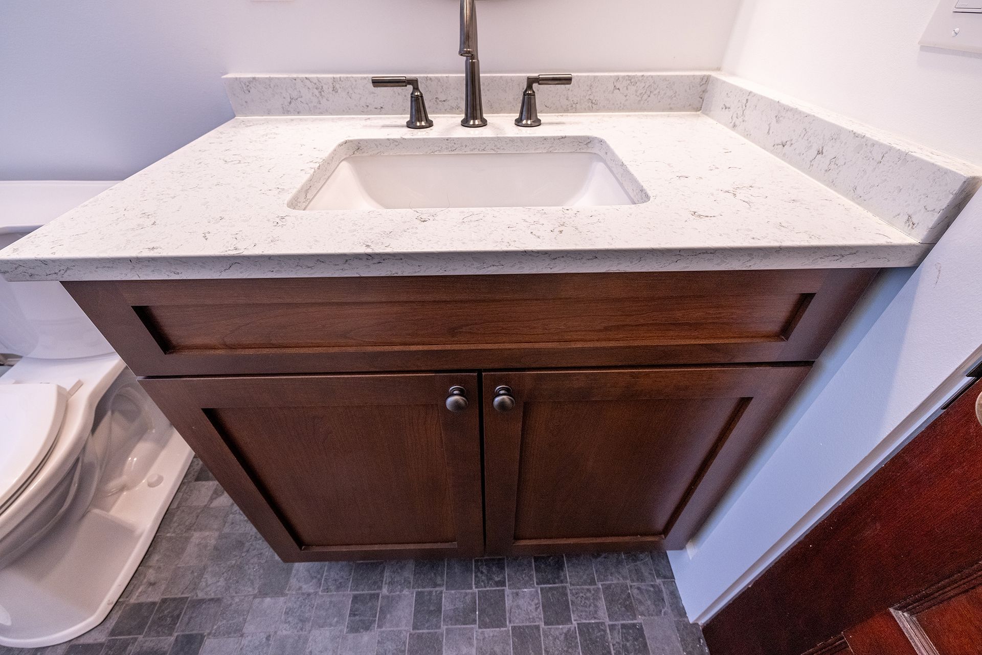 A bathroom vanity with a sink and a toilet.