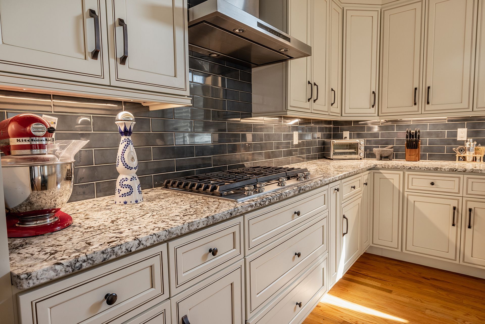 A kitchen with white cabinets and granite counter tops.