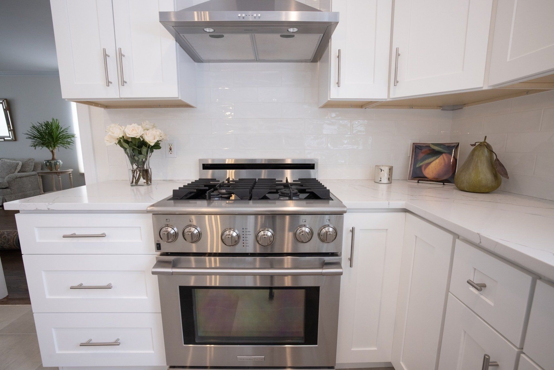 A kitchen with stainless steel appliances and white cabinets.