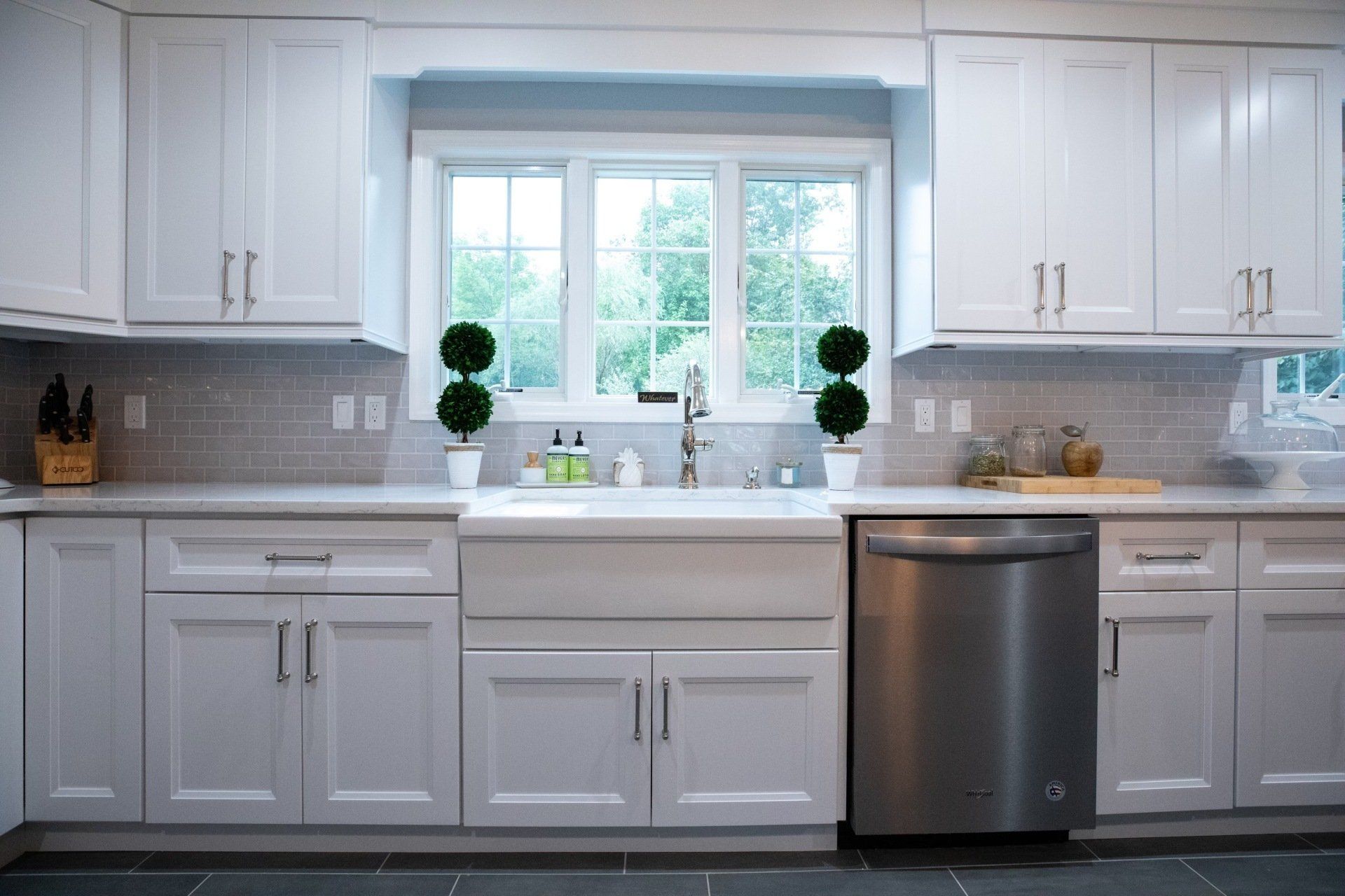 A kitchen with white cabinets and a stainless steel dishwasher.