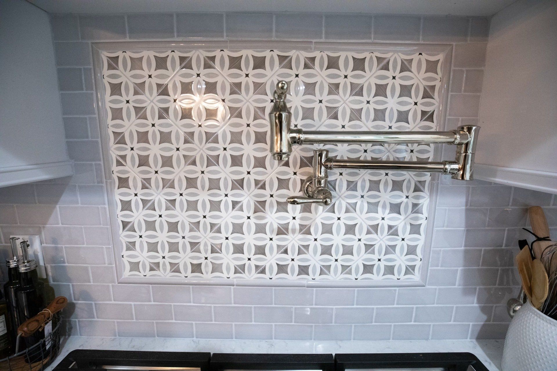 A kitchen with a stove top oven and a faucet on the wall.