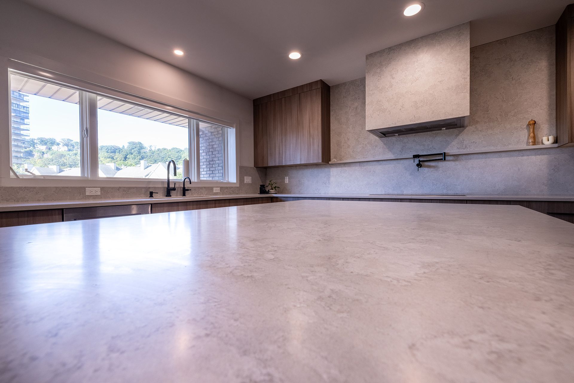 A kitchen with a large counter top and a large window.