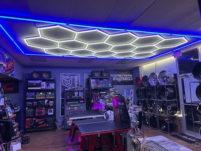 Car audio store interior with hexagonal ceiling lights and displays of car audio equipment.