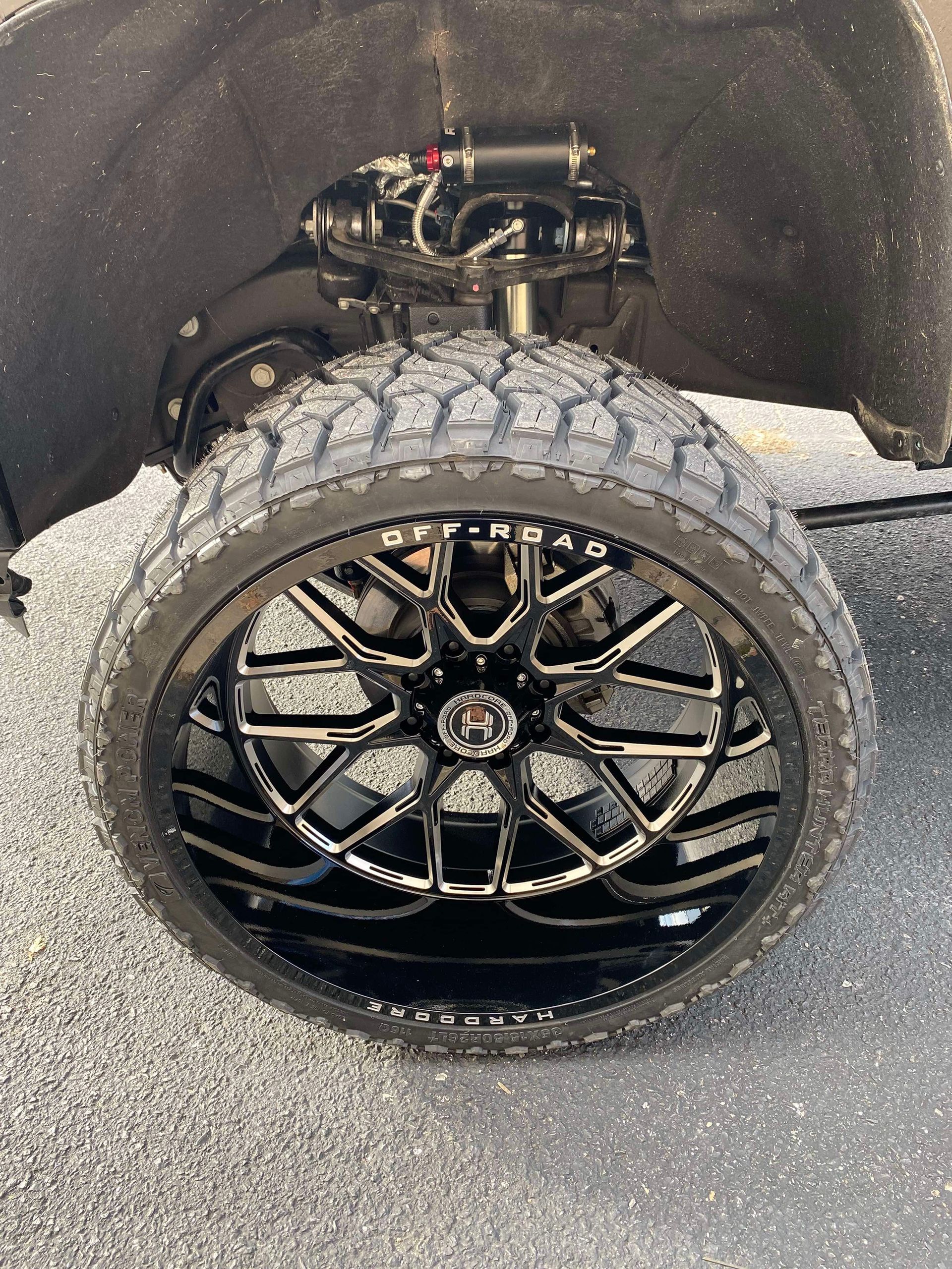 A close up of a tire on a truck with black wheels.
