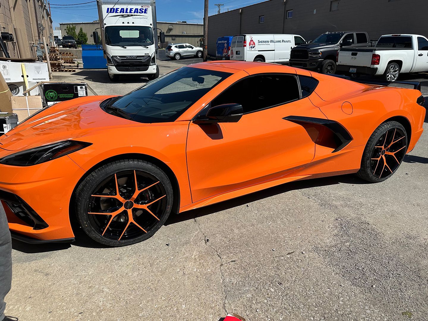 A bright orange sports car is parked in a parking lot.