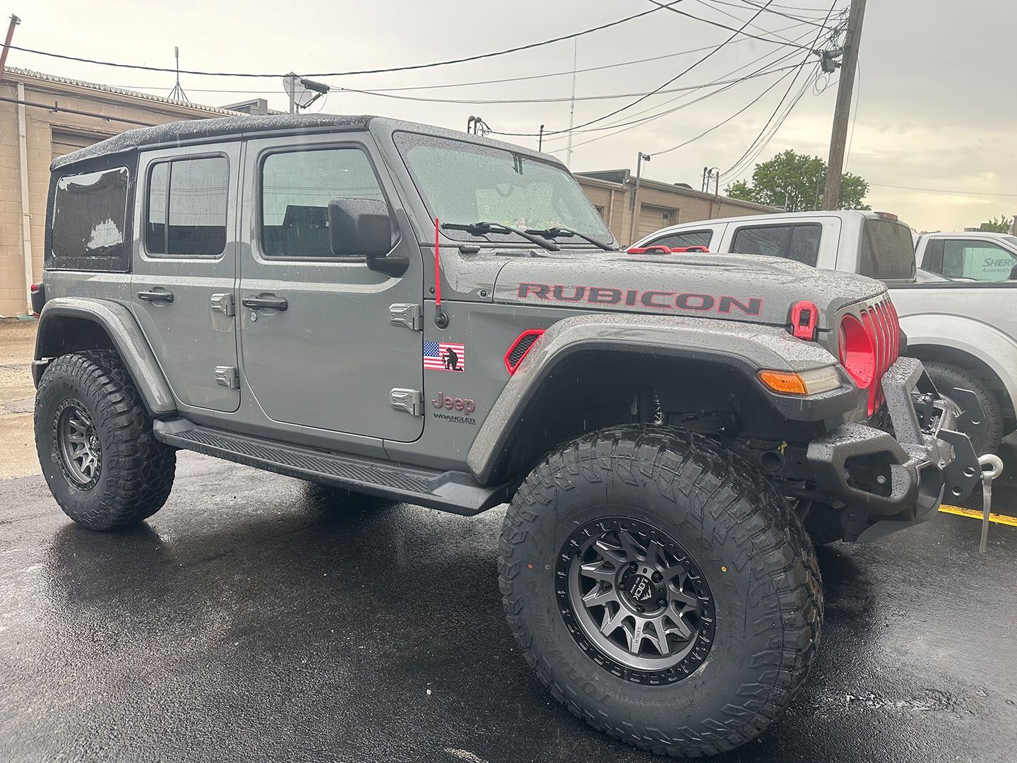 A Jeep Wrangler Rubicon is parked in a parking lot.