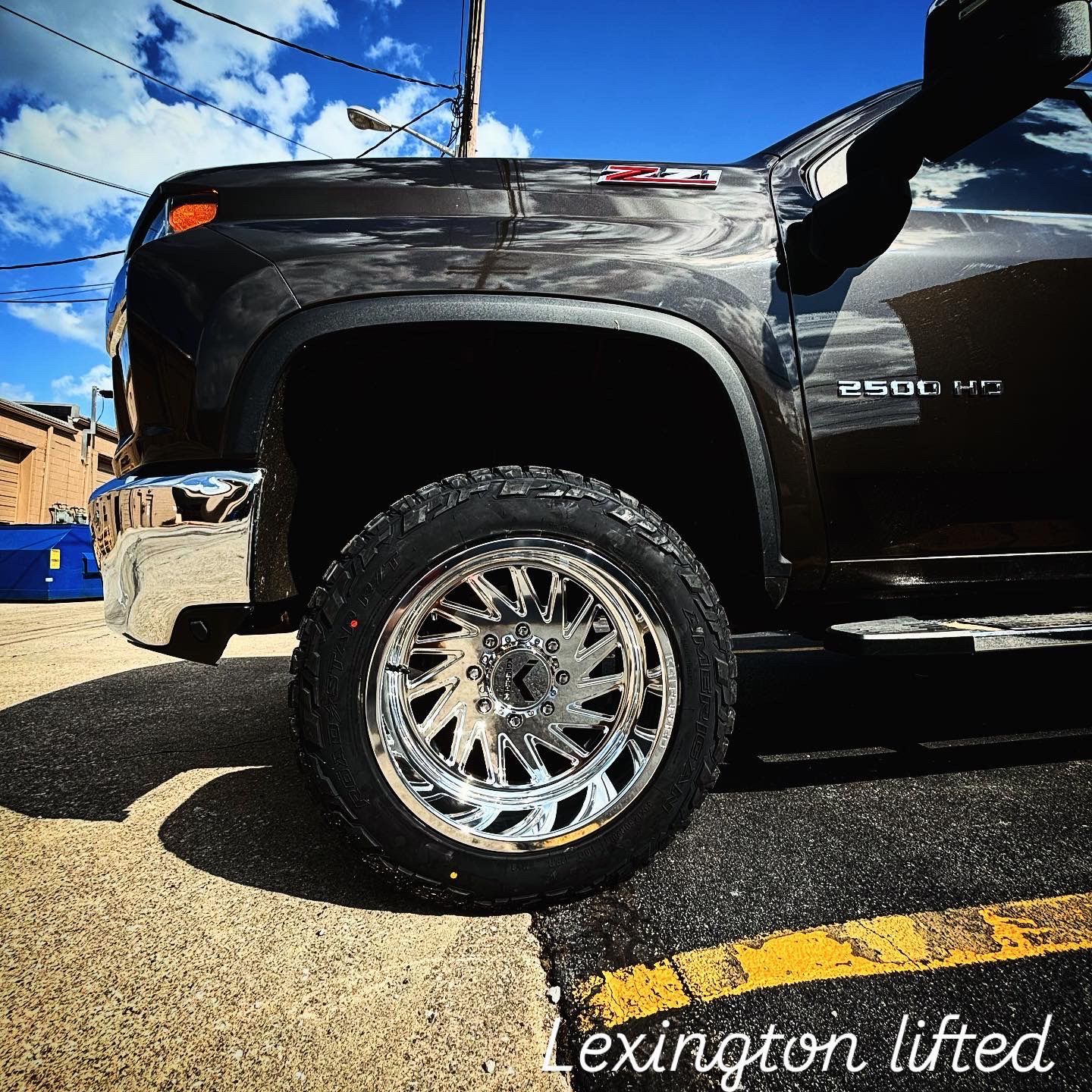 A Lexington lifted truck is parked in a parking lot