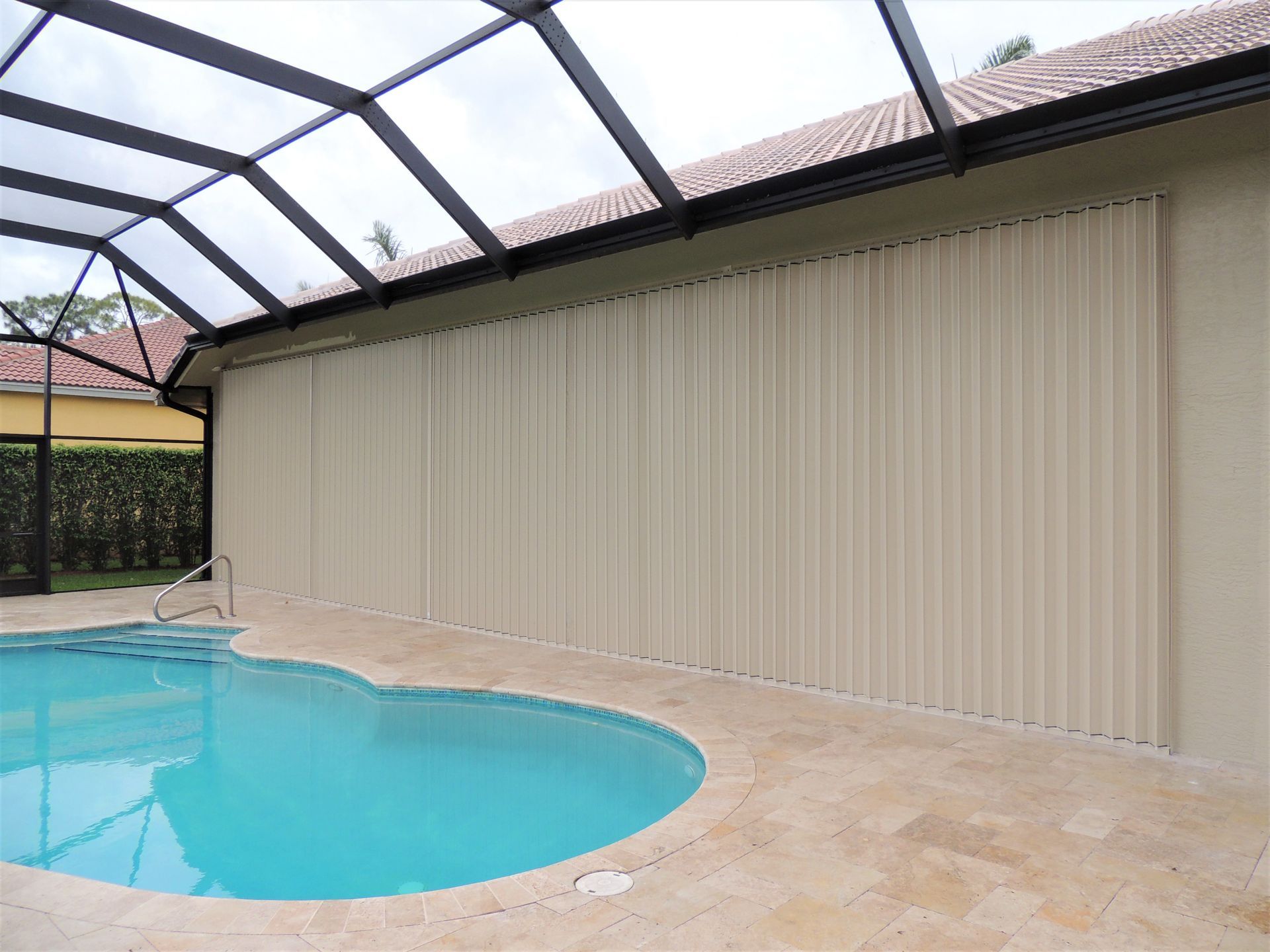 There is a large swimming pool in the backyard of a house.