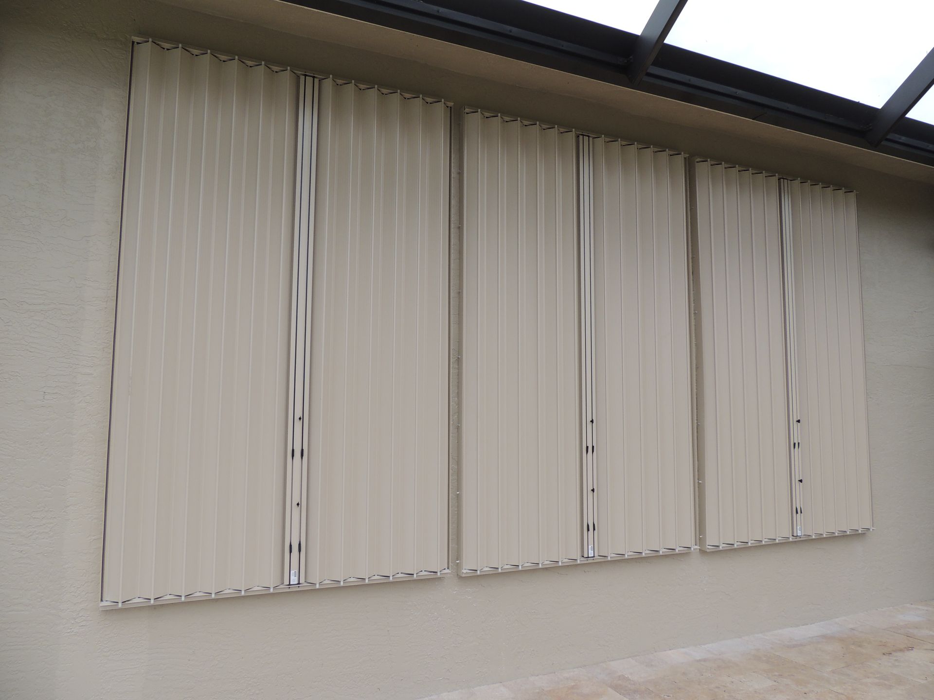 A row of white vertical blinds on the side of a building.