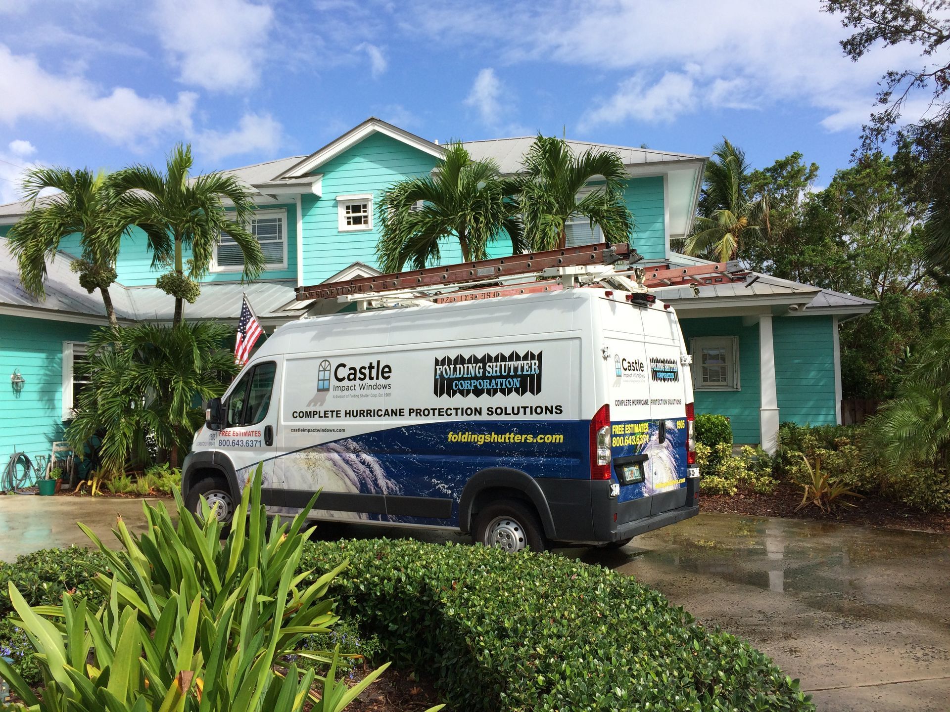 A van is parked in front of a blue house.