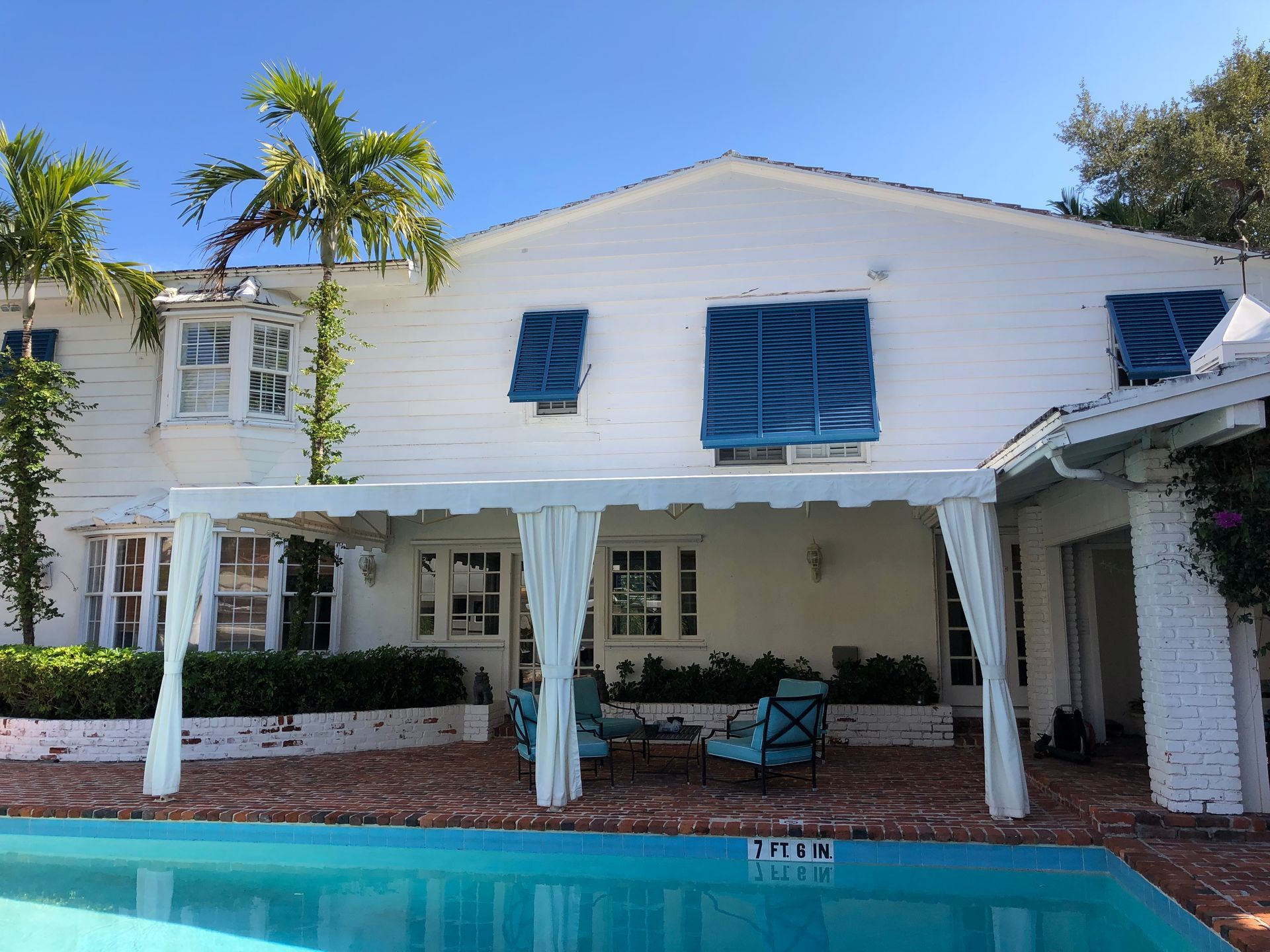 A large white house with a swimming pool in front of it