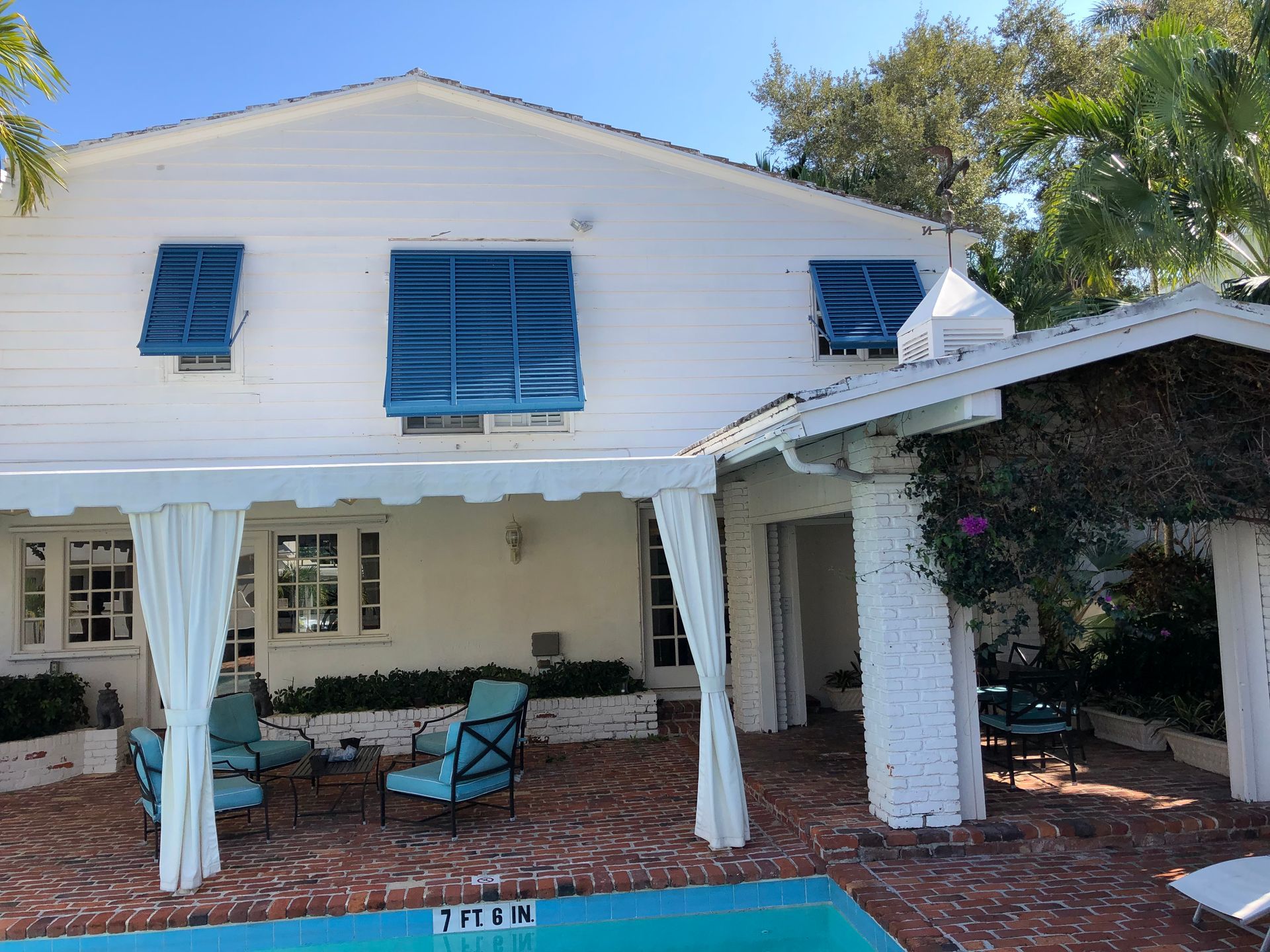 A white house with a swimming pool in front of it