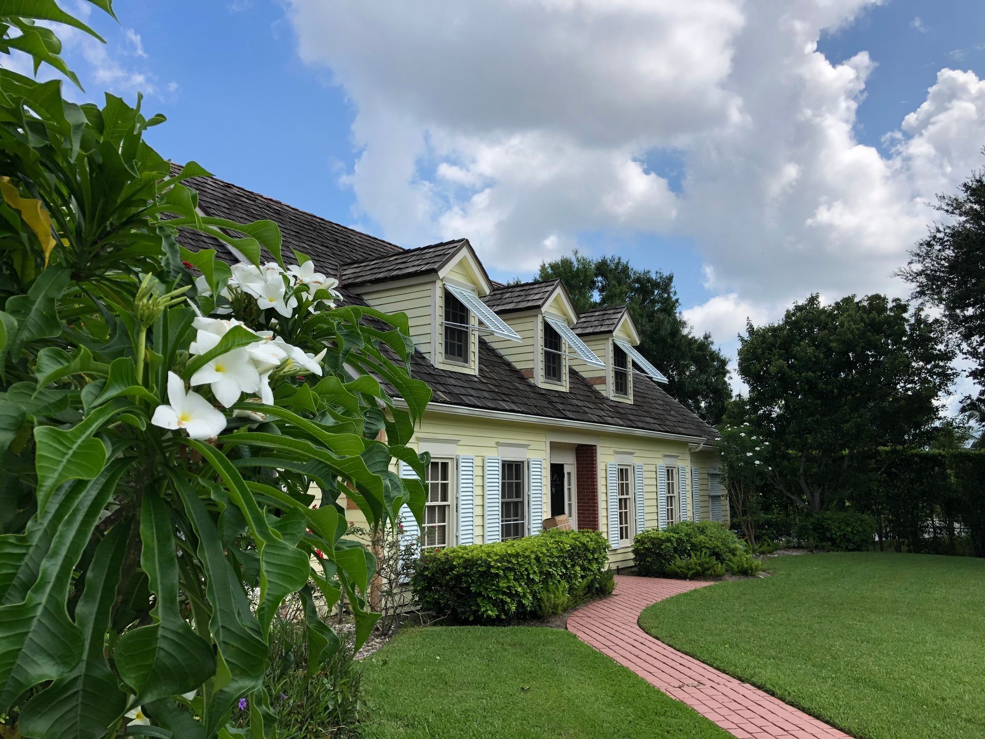 A house with a red brick walkway leading to it