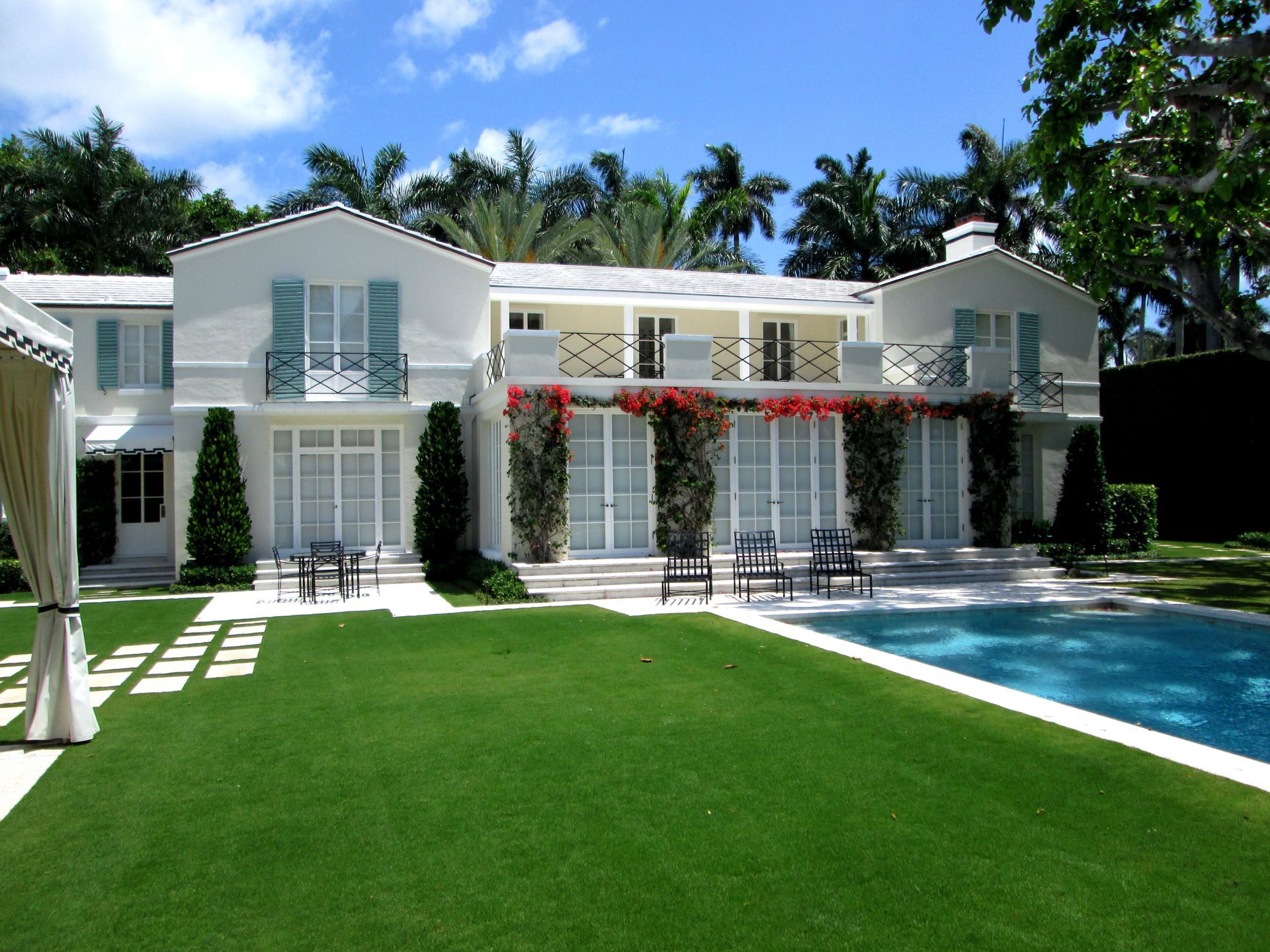 A large white house with a swimming pool in front of it