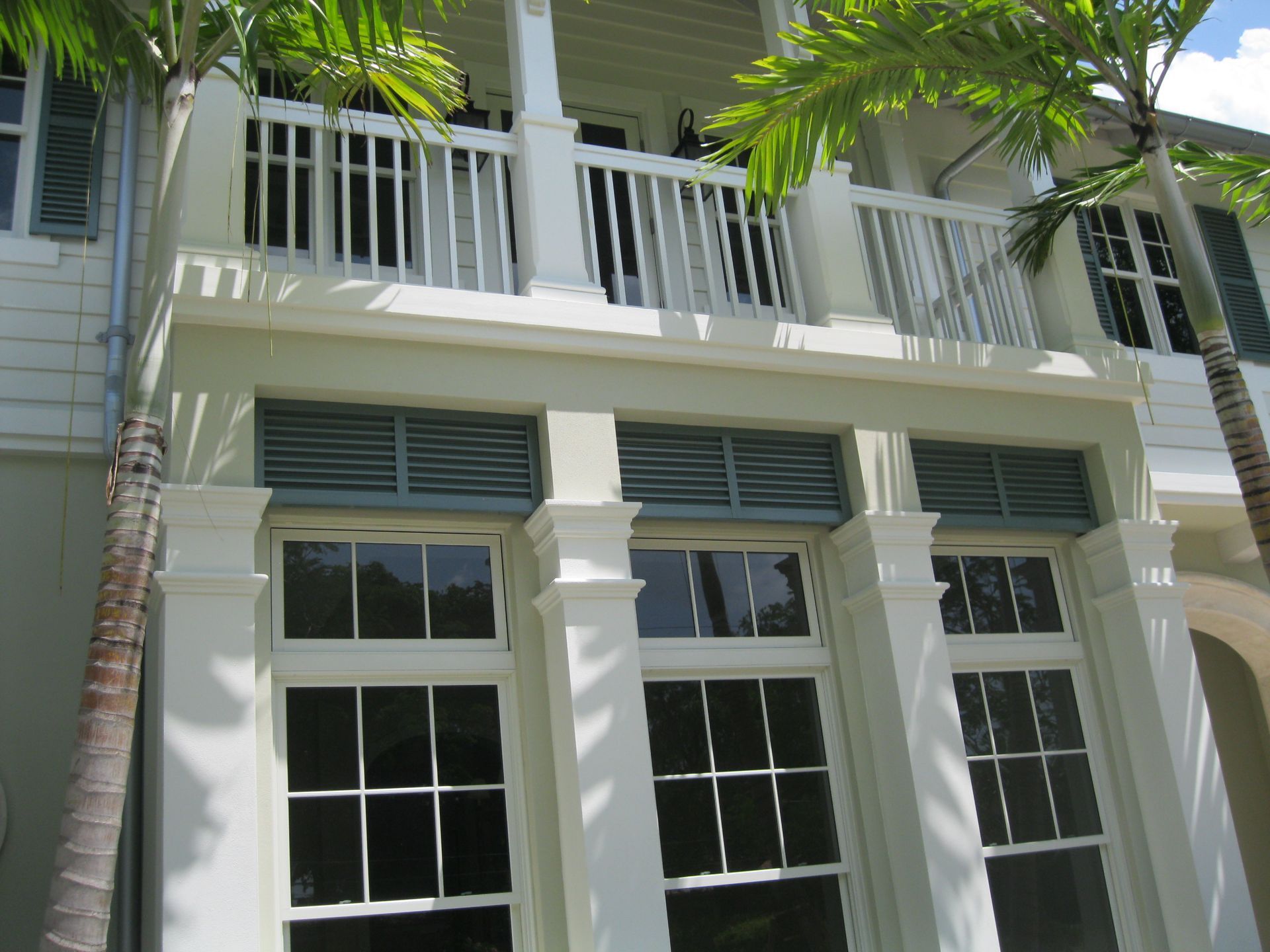 A white house with a balcony and lots of windows