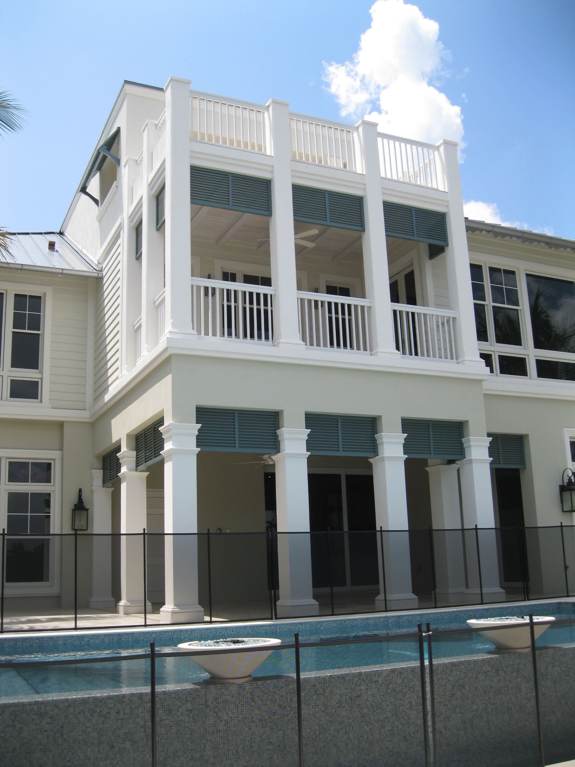 A large white house with a swimming pool in front of it