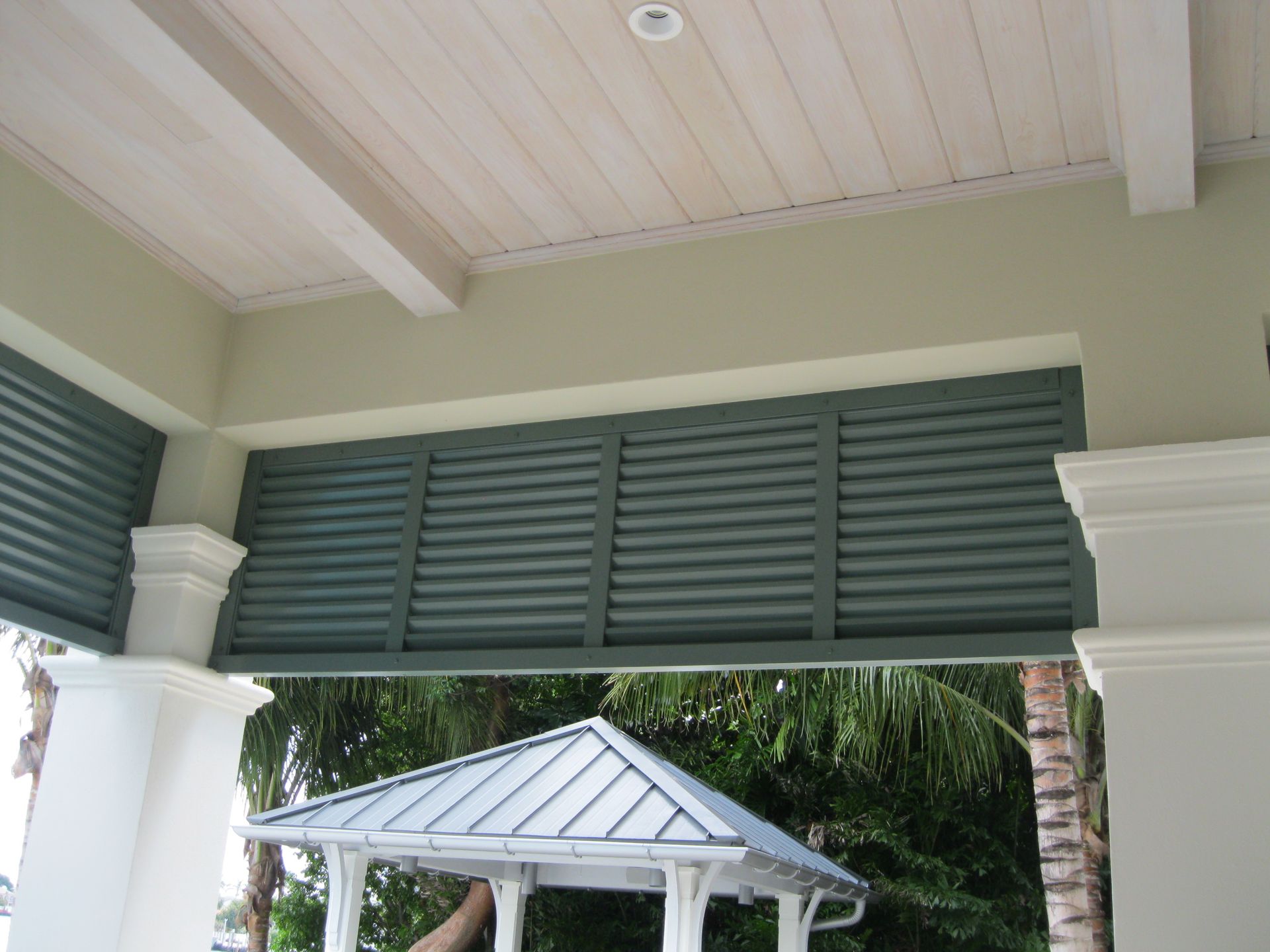 A gazebo with a roof that has shutters on it