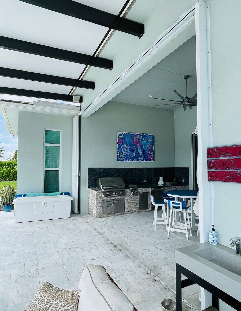 A patio with a table and chairs and a grill