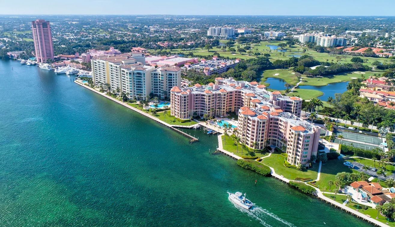 An aerial view of a city with a boat in the water.