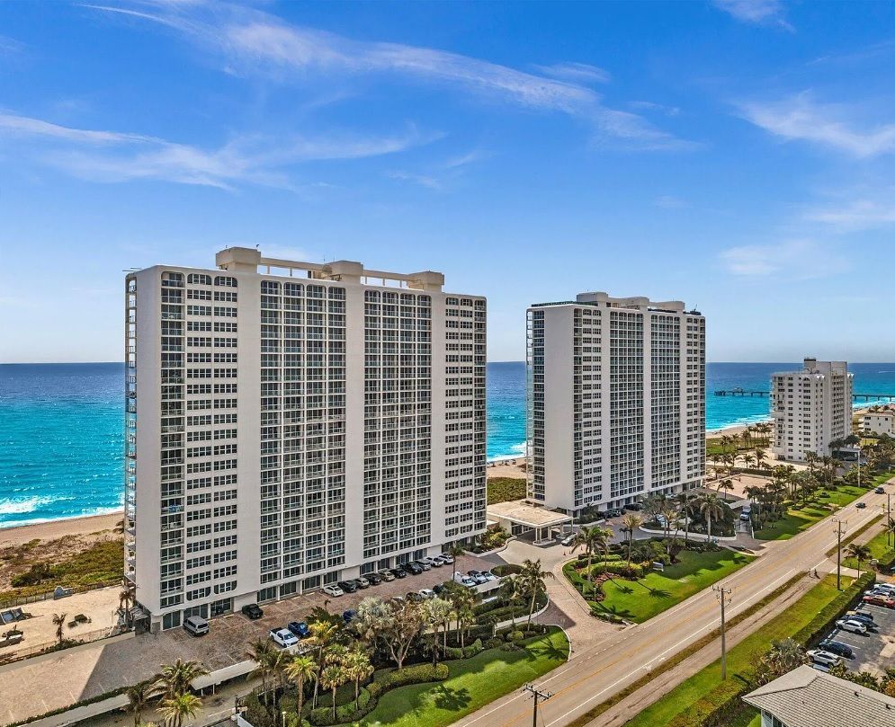 An aerial view of a row of tall buildings next to the ocean.