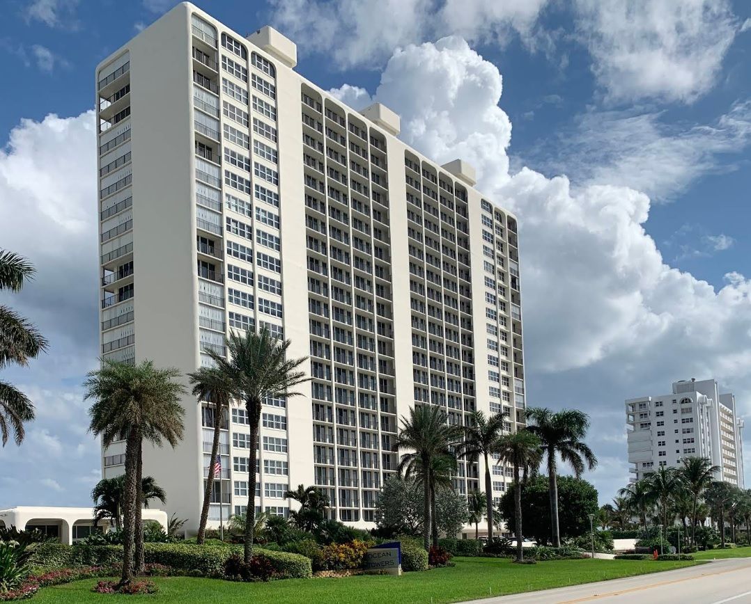 A tall building with palm trees in front of it