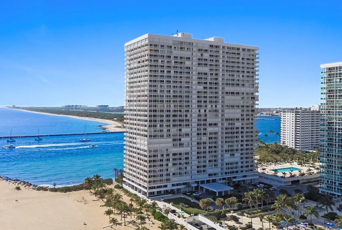 An aerial view of a large building next to a beach.