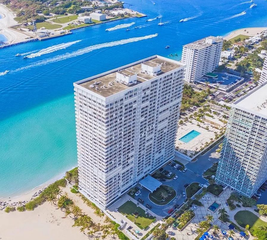 An aerial view of a large building next to a body of water