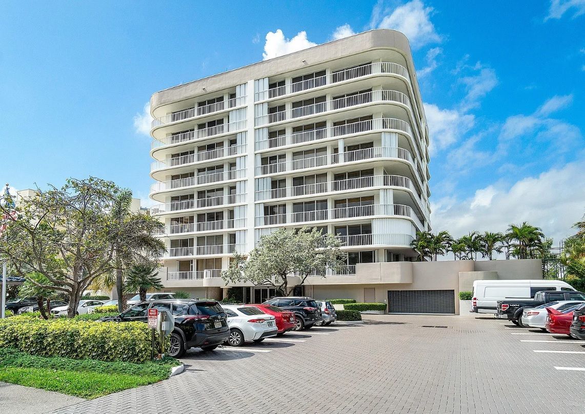 A large building with a lot of cars parked in front of it