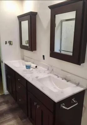 Double vanity with dark cabinets, white marble countertop, and two matching wall-mounted medicine cabinets.