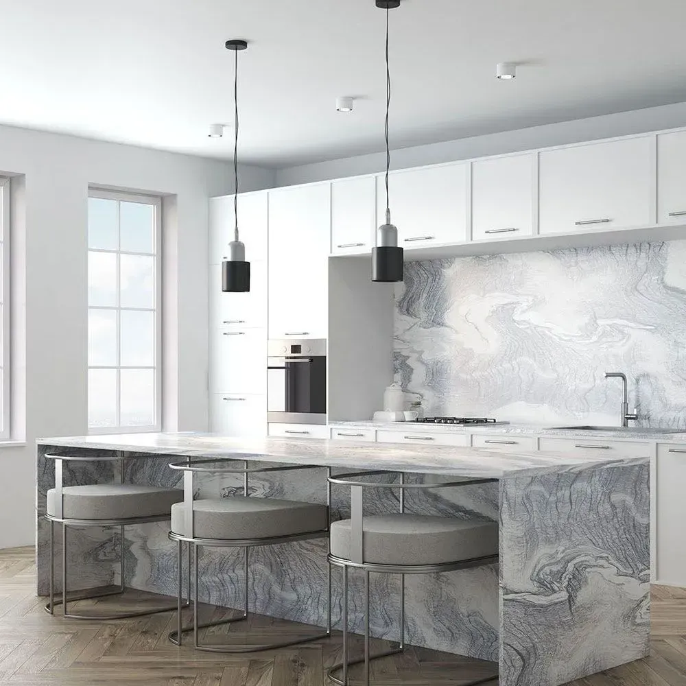 A modern kitchen featuring a marble-patterned island with three light gray stools, white cabinets, and two pendant lights.