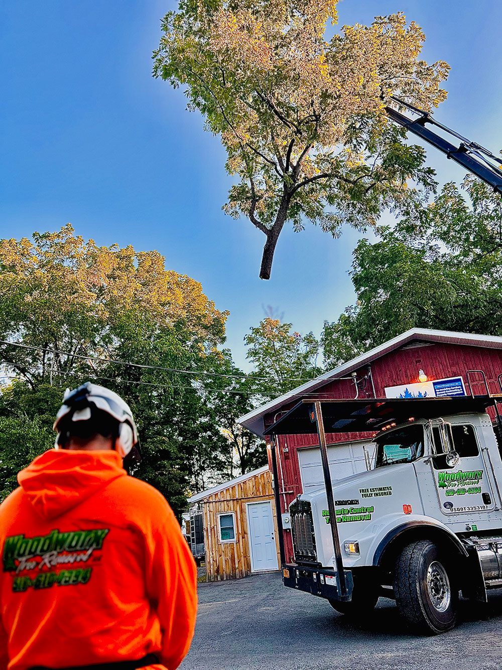A man in an orange hoodie is standing in front of a truck.