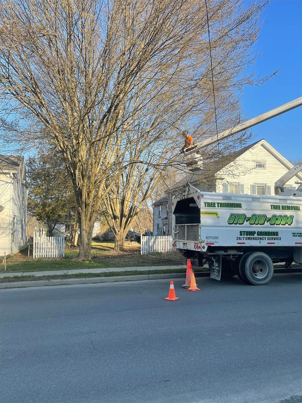A tree trimming truck is parked on the side of the road.