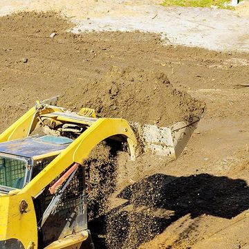 A yellow bulldozer is digging a hole in the dirt