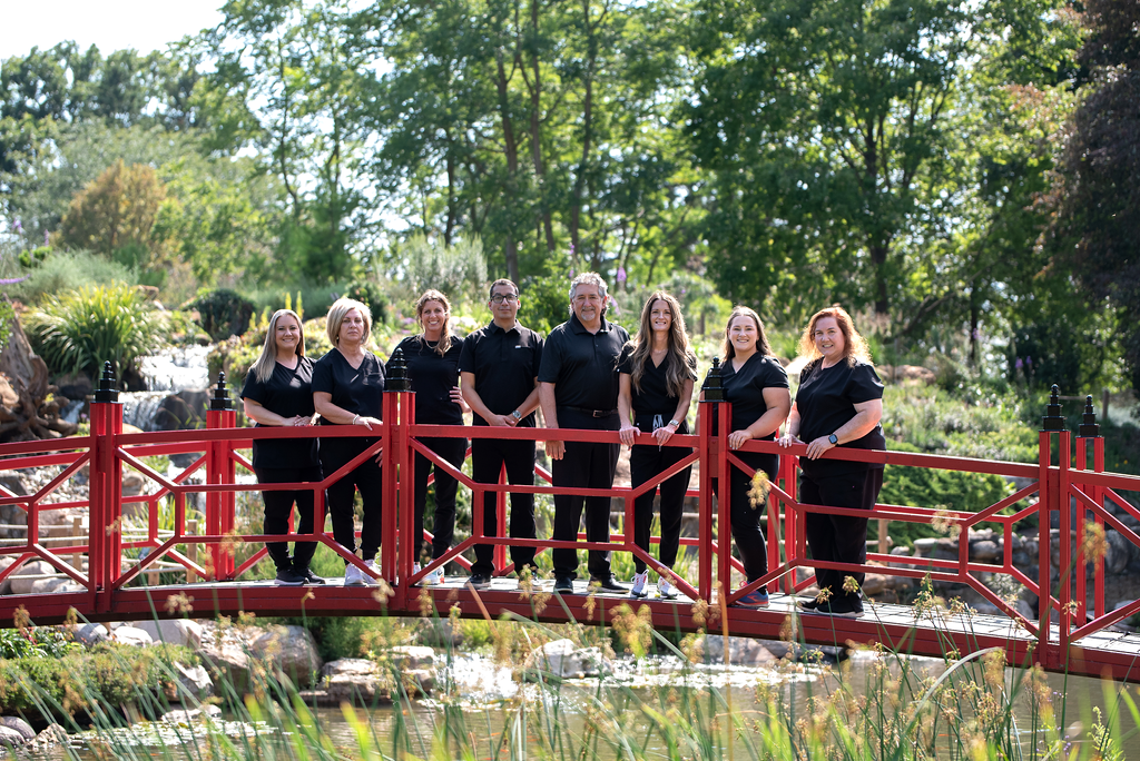 A group of people are standing on a red bridge.