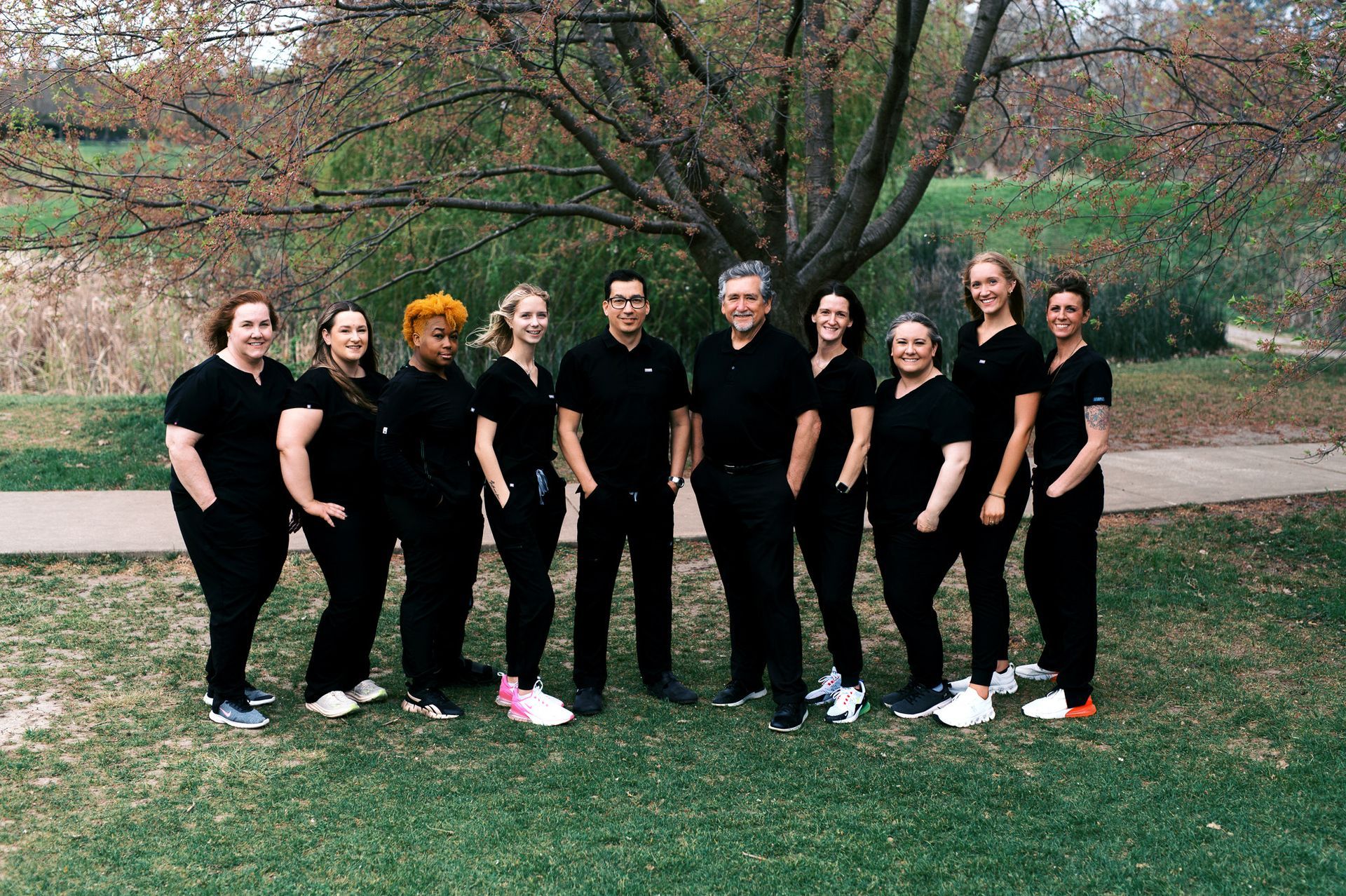 A group of people is posing for a picture in a park.