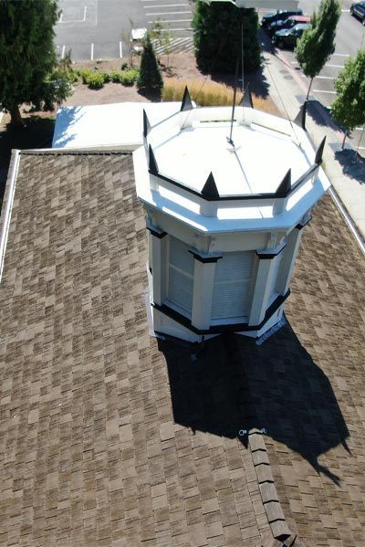 An aerial view of a building with a clock tower on top of it