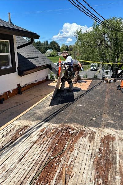 A man is working on the roof of a house.