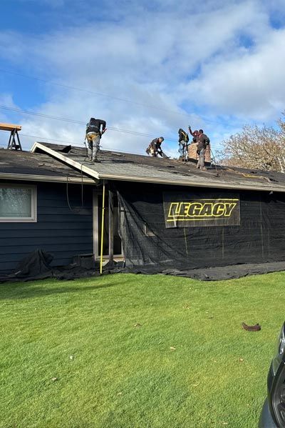A group of men are working on the roof of a house.