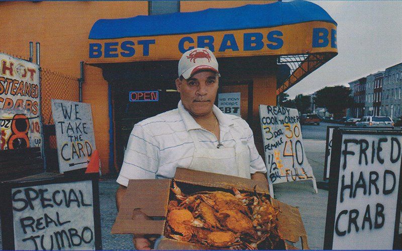 Man holding crab in front of Best Crab location