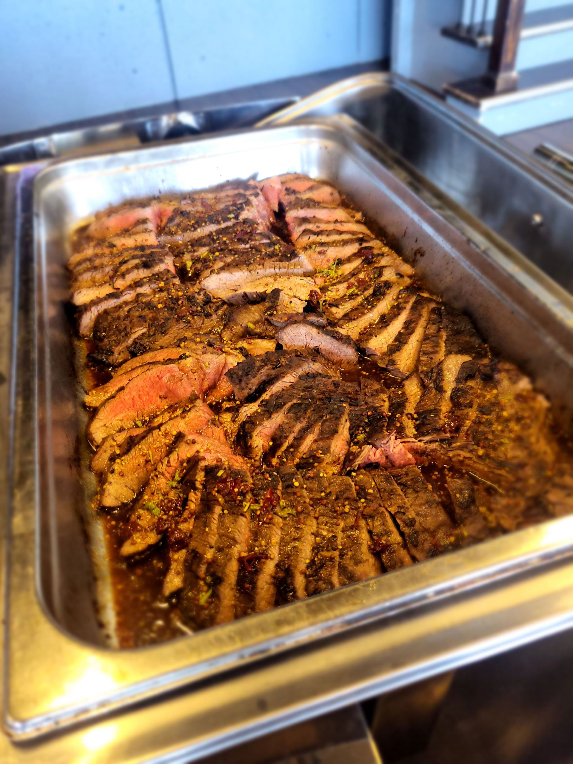 A tray of meat is sitting on a counter.