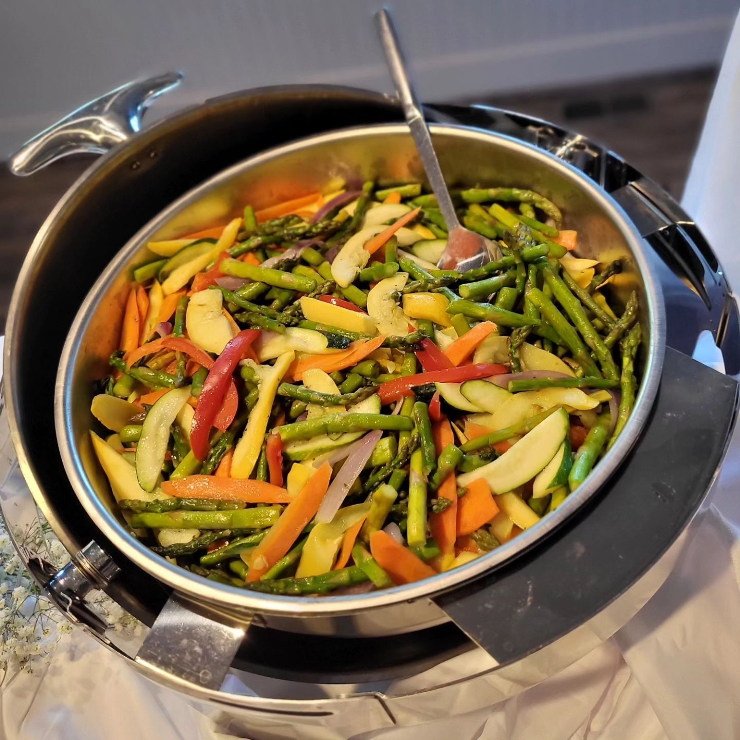 A bowl of vegetables with a spoon in it