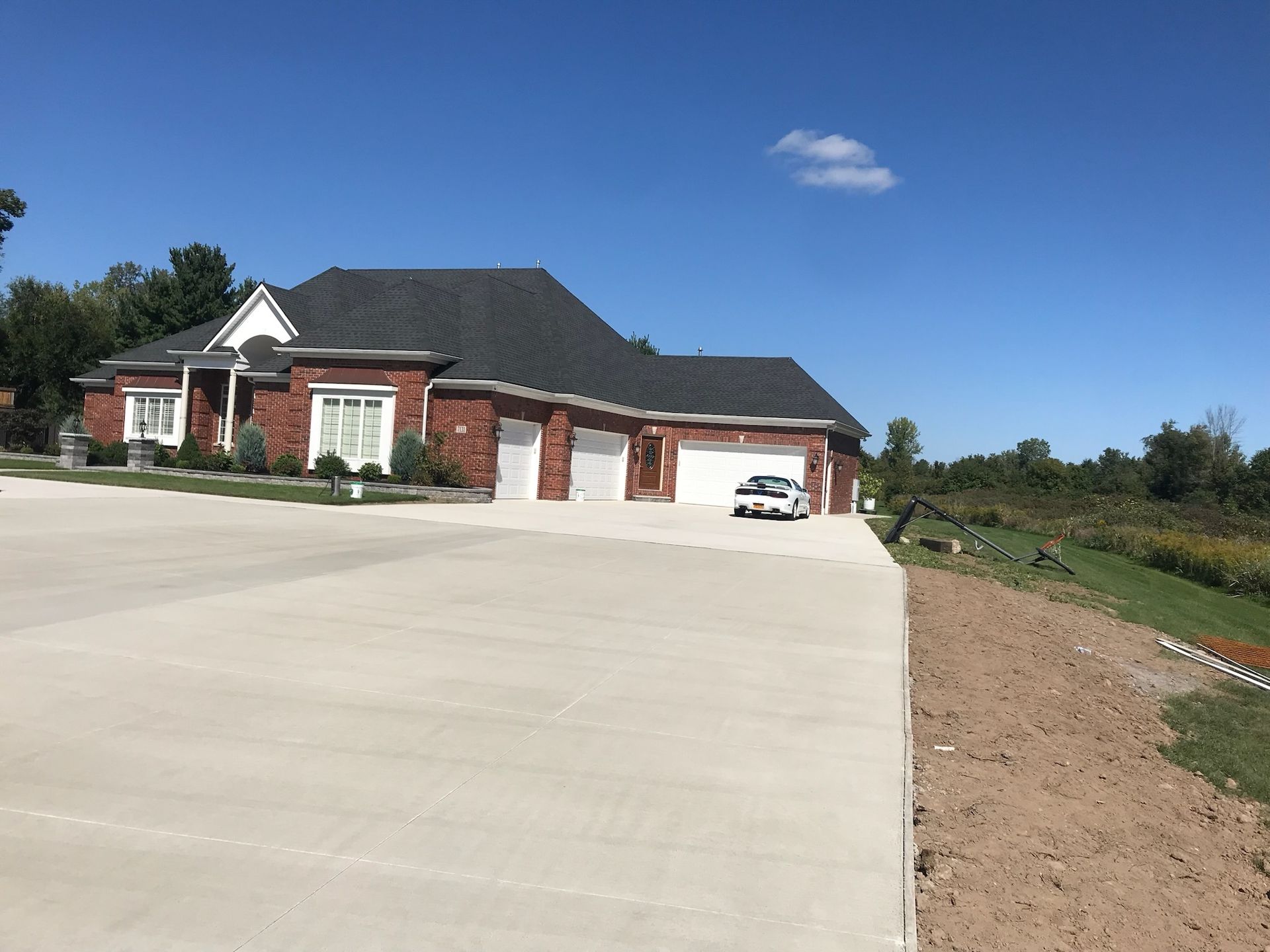 A large brick house with a car parked in front of it.