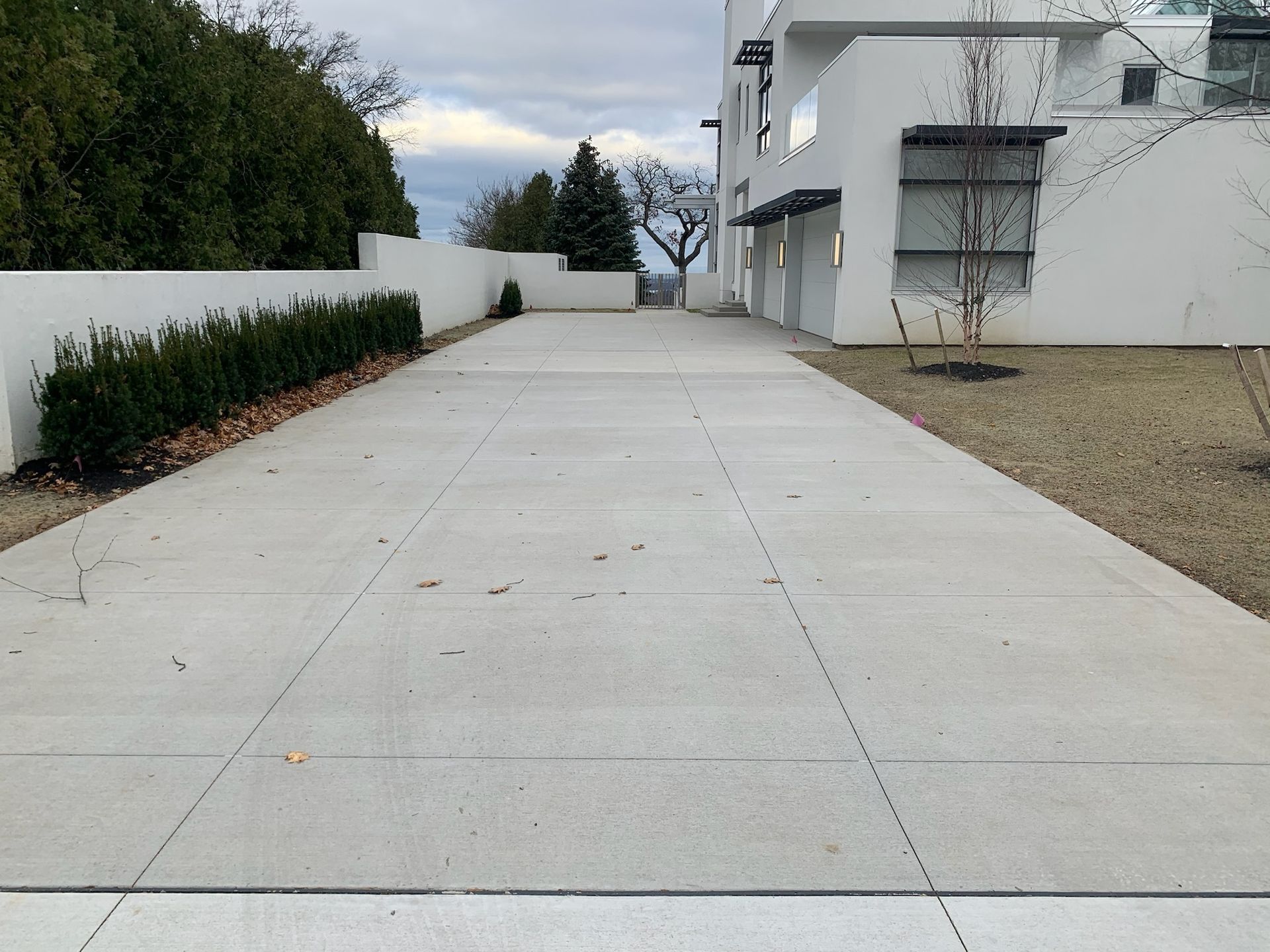 A concrete driveway leading to a white building