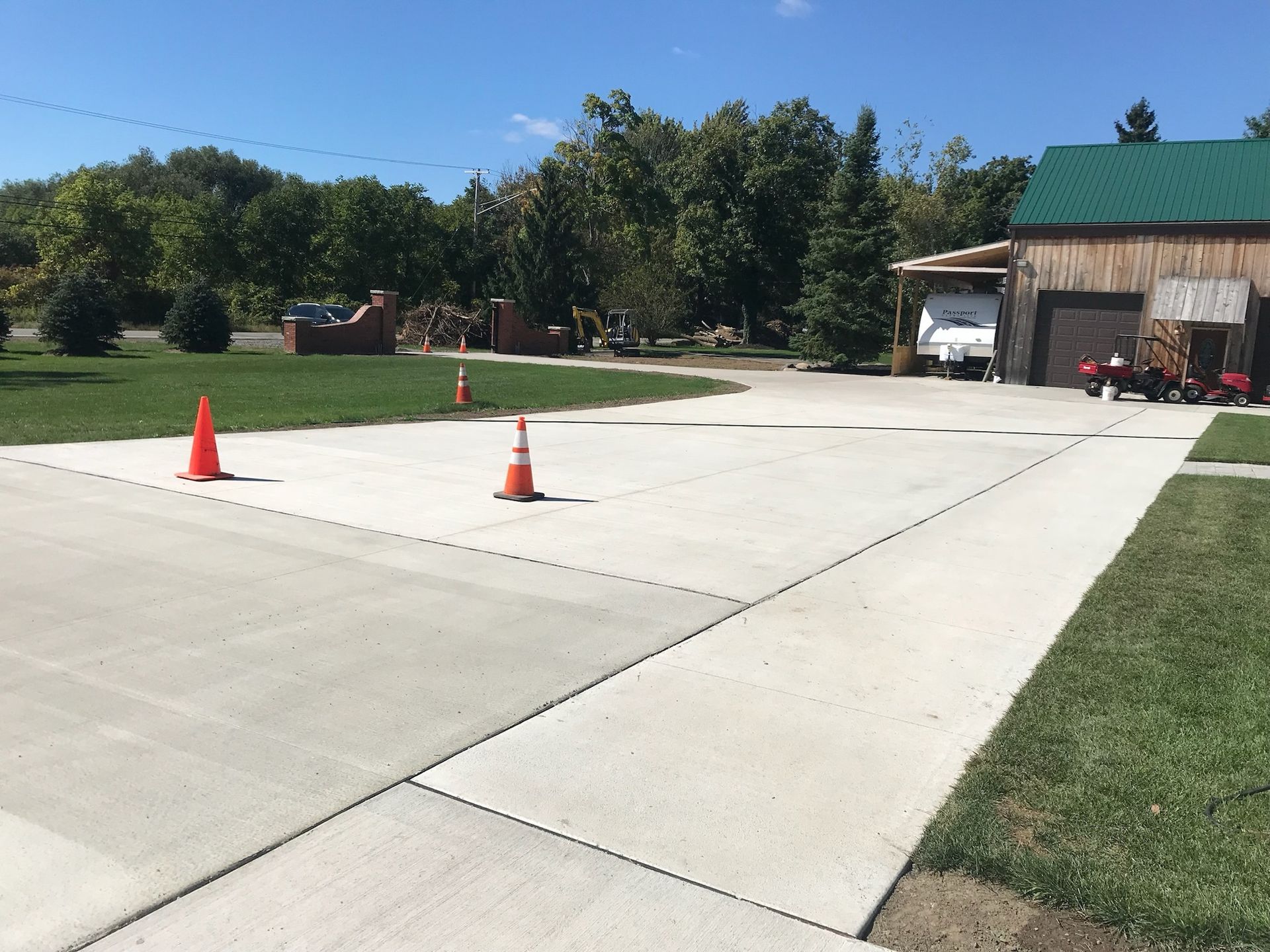 A concrete driveway with two orange cones on it