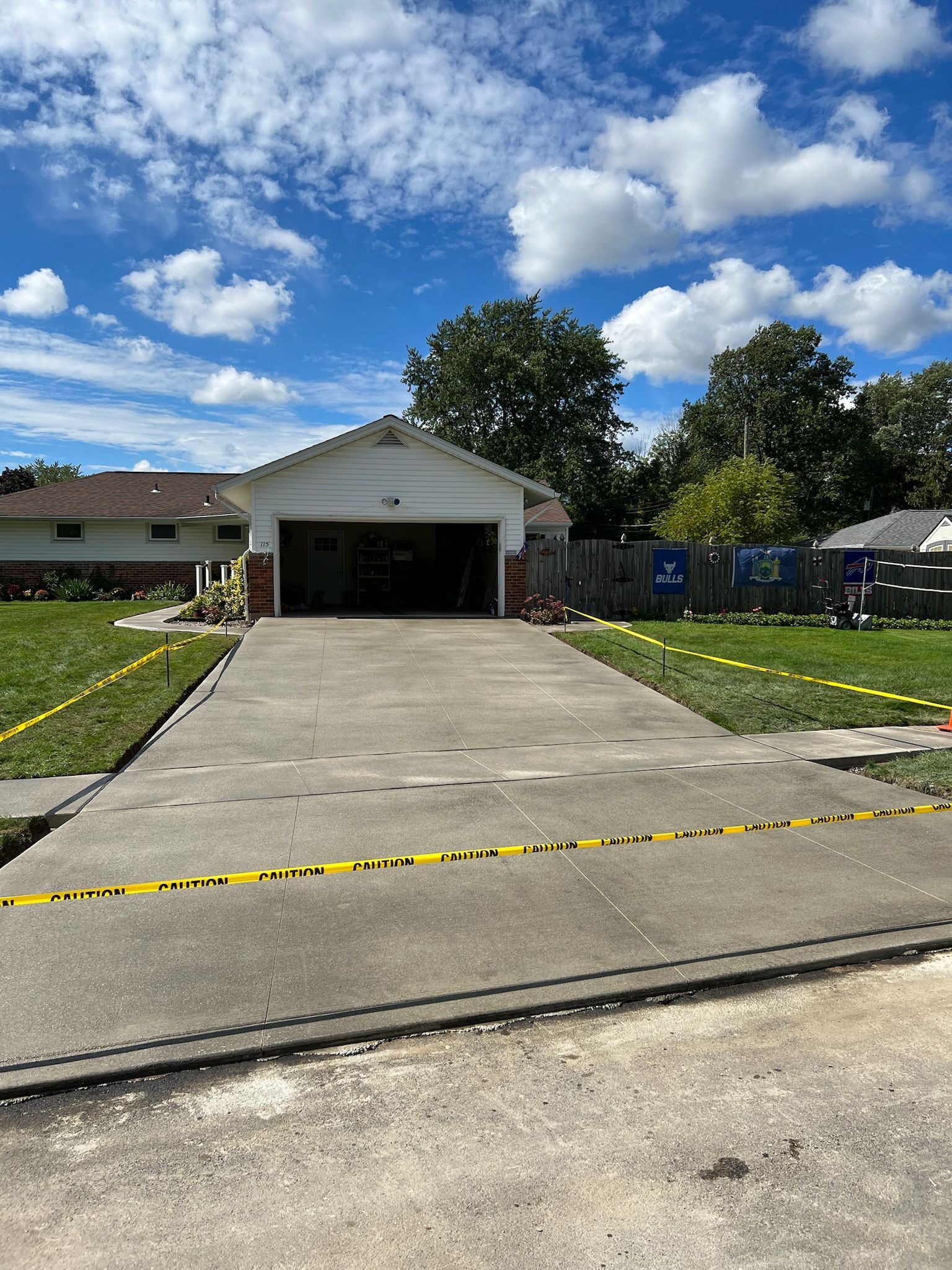 A concrete driveway is being built in front of a house.