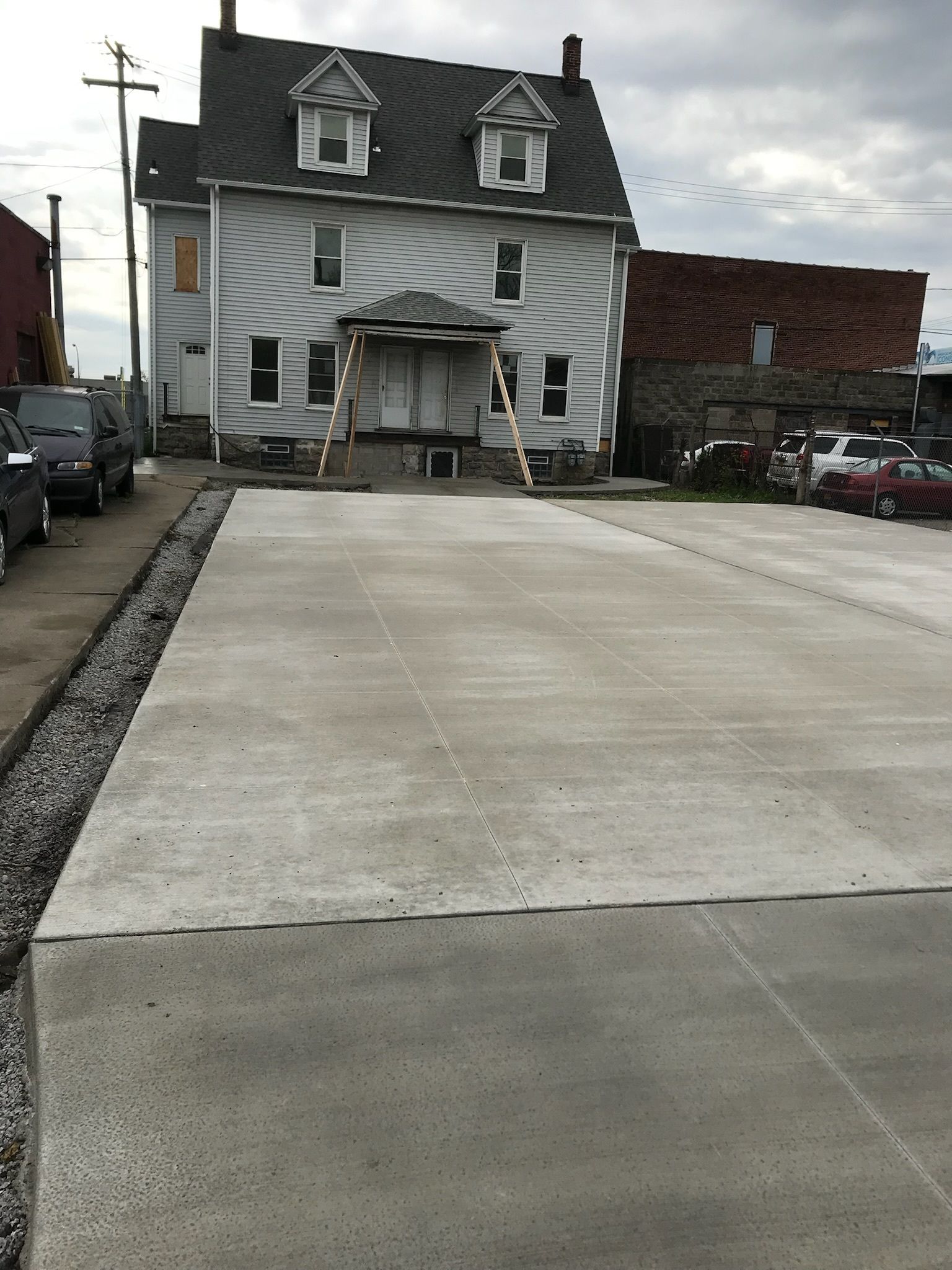 A large white house with a concrete driveway in front of it